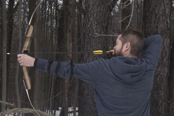 Scott engages in some target practice with his bow and arrow—he hopes to get his daughters interested in the sport of archery.