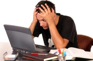 Young man having trouble studying, on white background